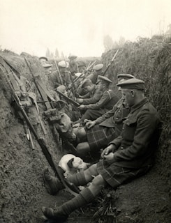 a group of scottish soldiers men sitting next to each other in a trench