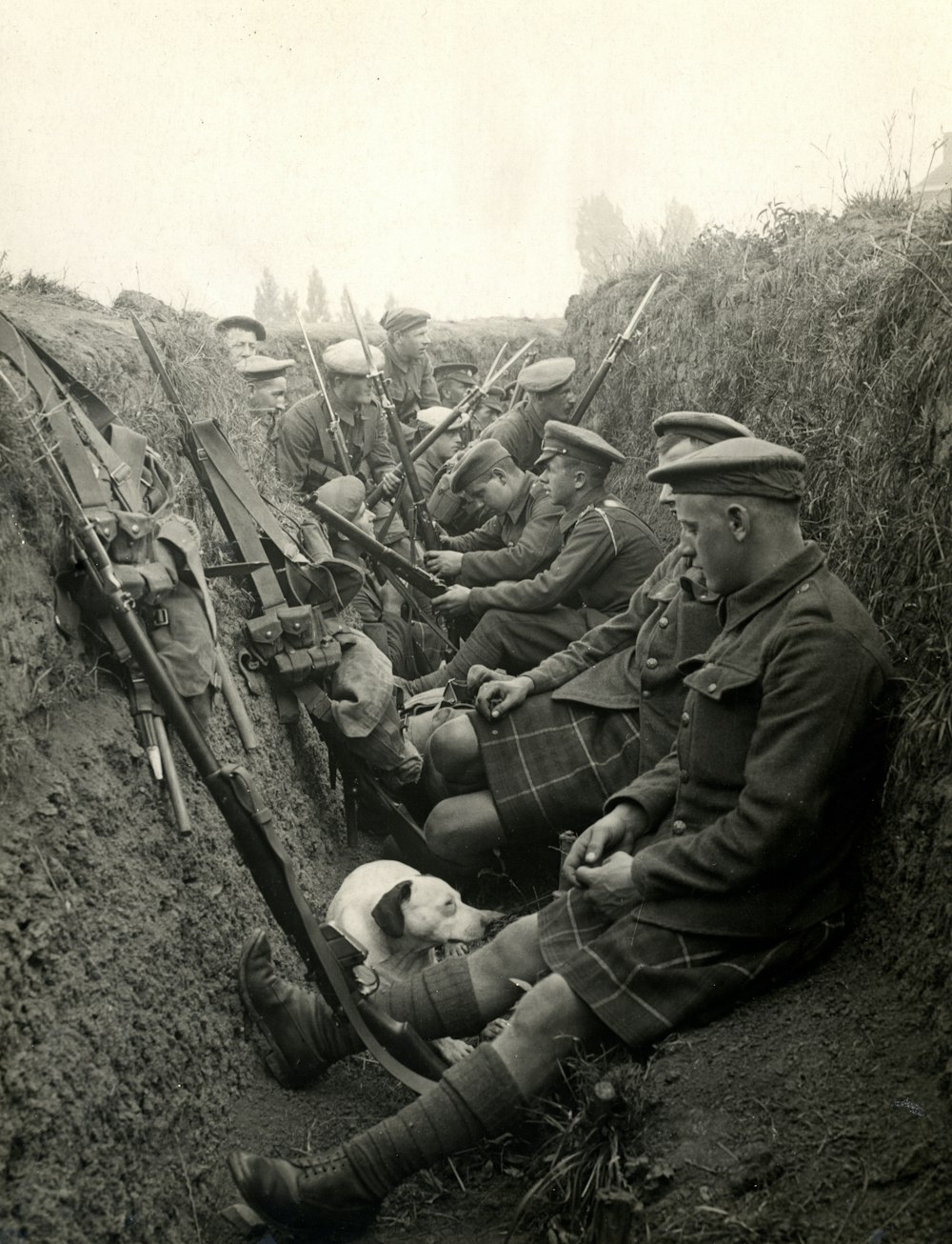 塹壕で隣同士に座っている男性のグループ