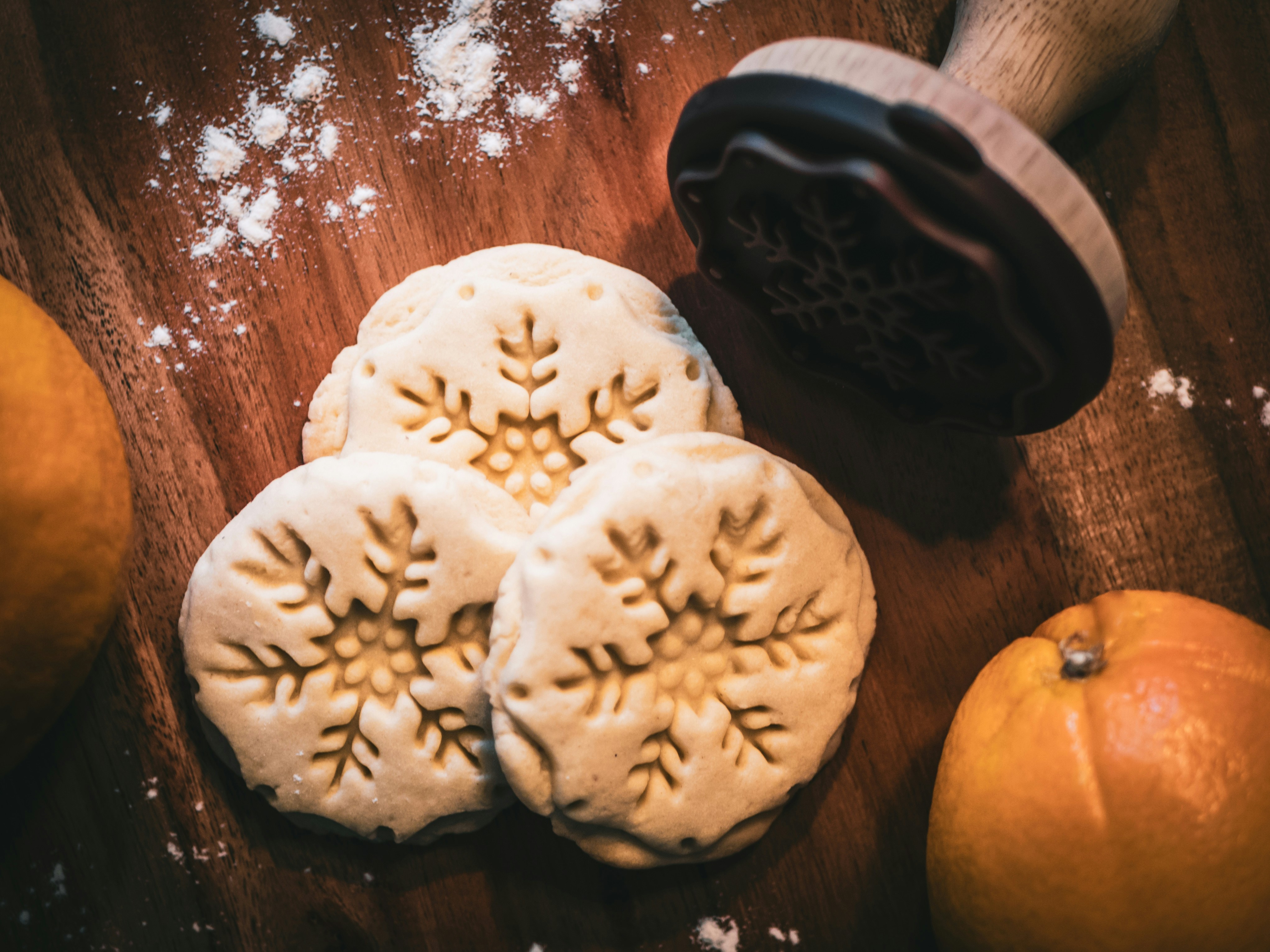 three snowflakes print cookies near orange fruit