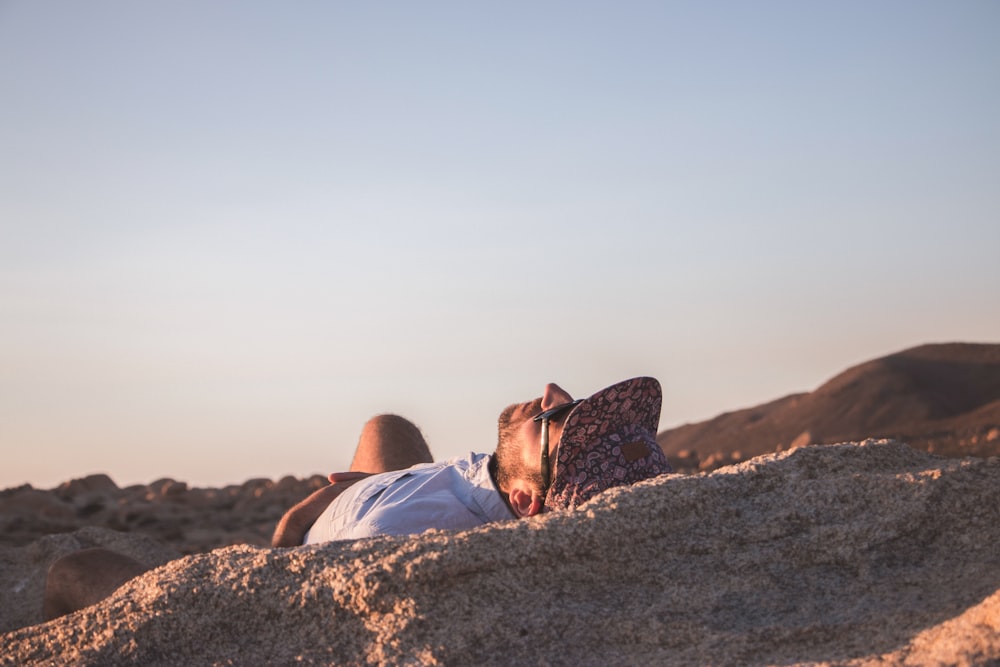 man wearing sunglasses while sunbathing