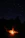 A joyful group sitting around a warm campfire under starry mountains.