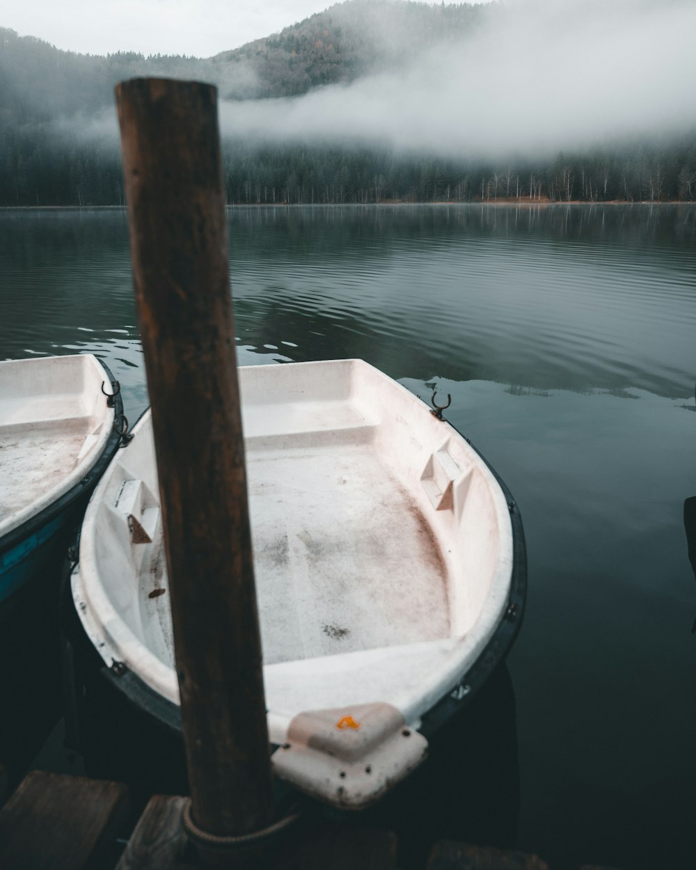 white boat on dock near mountain