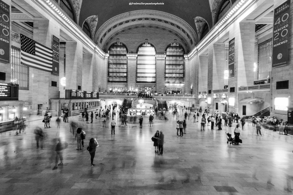 grayscale photo of people standing inside building