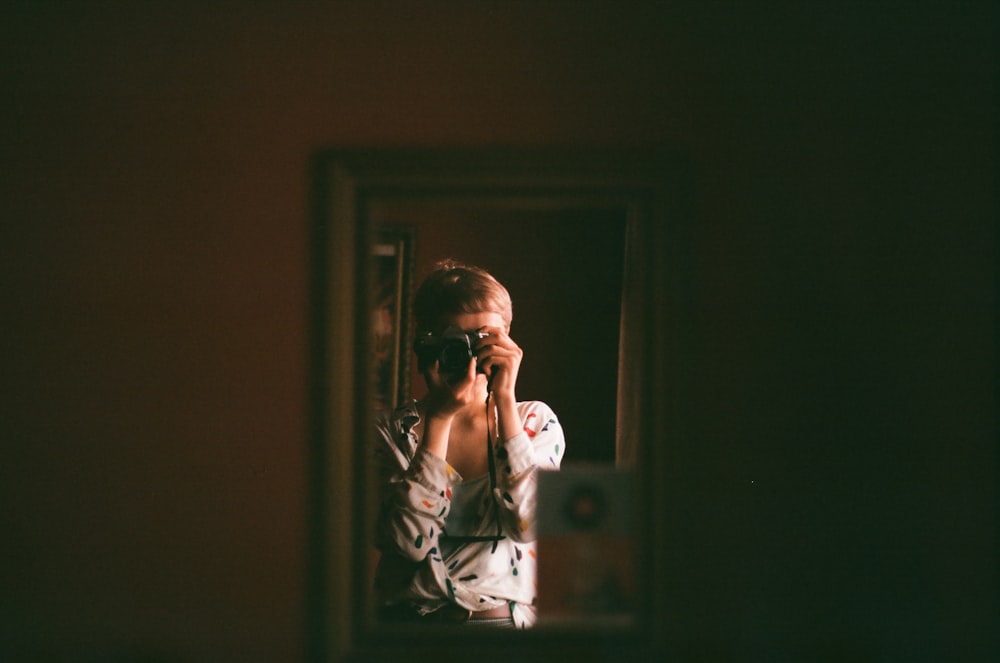 woman taking selfie in front of mirror