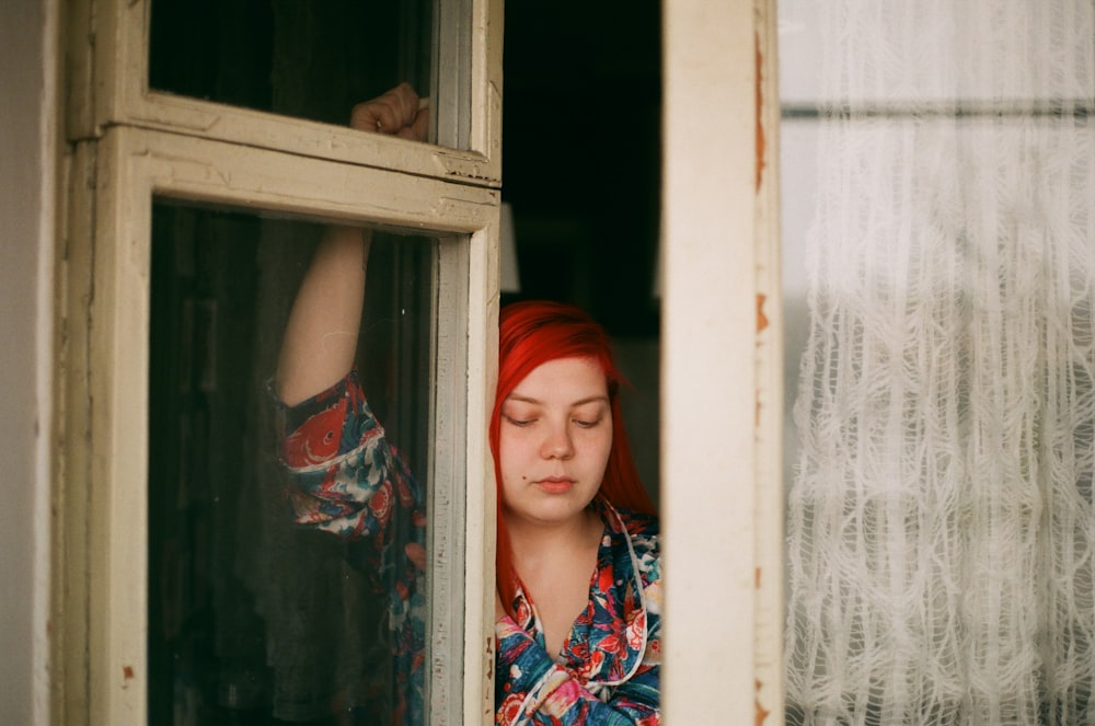 woman standing beside window