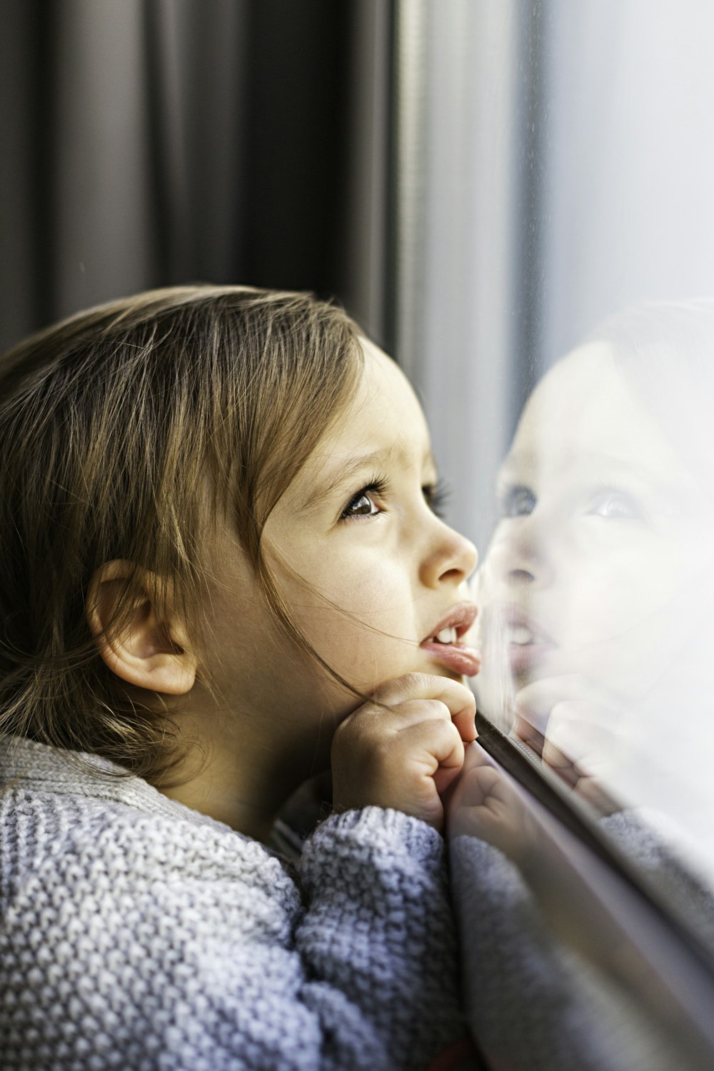 girl standing near glass window