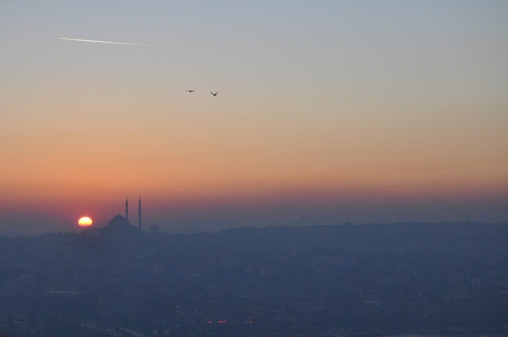 the sun is setting over a city skyline