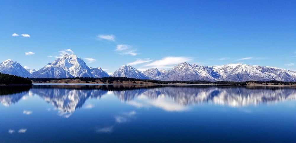 montagne innevate vicino allo specchio d'acqua