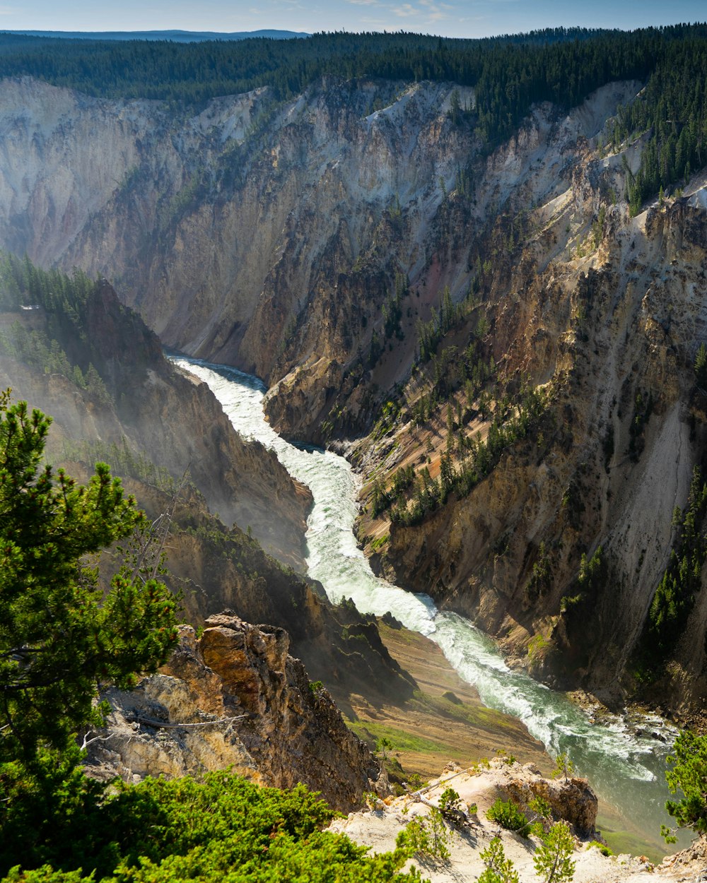 aerial photography of flowing body of water between mountains