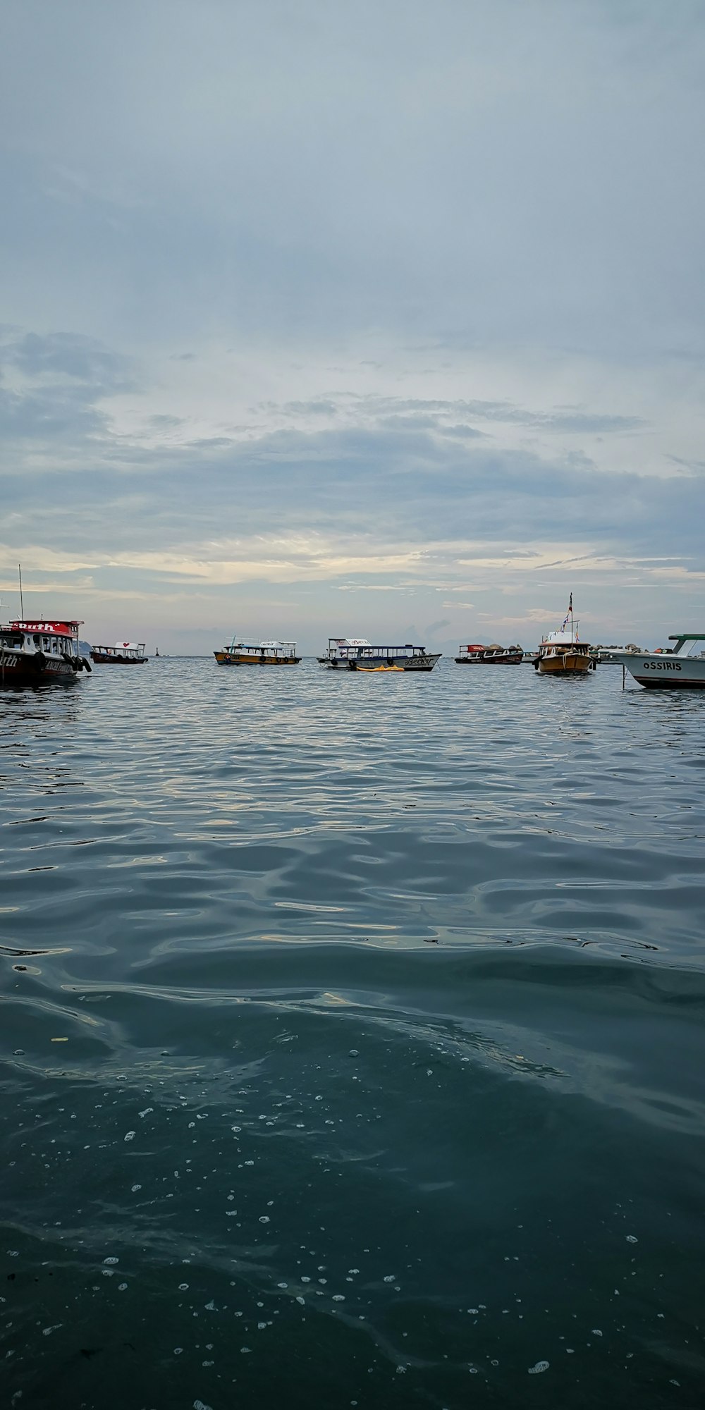 boats on water under white skies during daytime