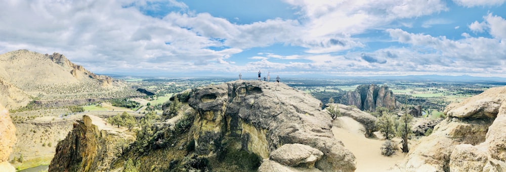 people on top of rock formation during daytime