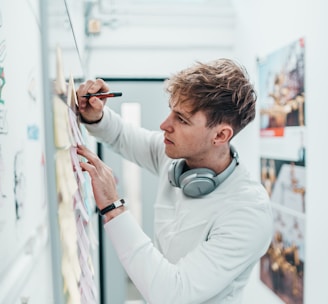 man with pen writing on wall