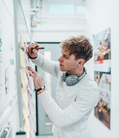 man with pen writing on wall