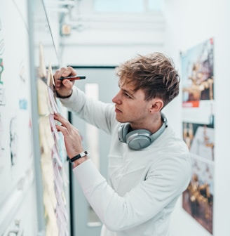 man with pen writing on wall