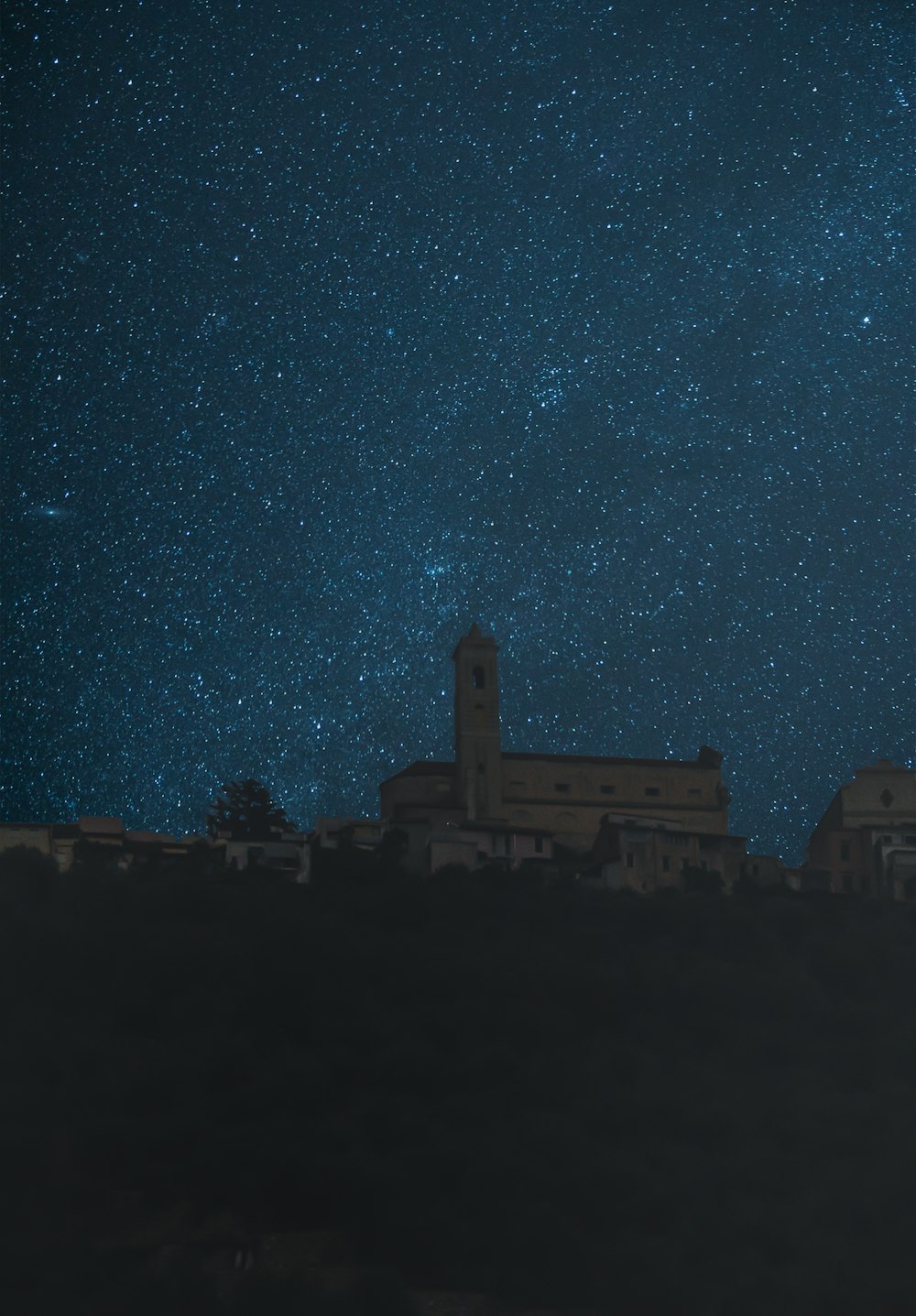 low-angle photography of church under a starry night sky