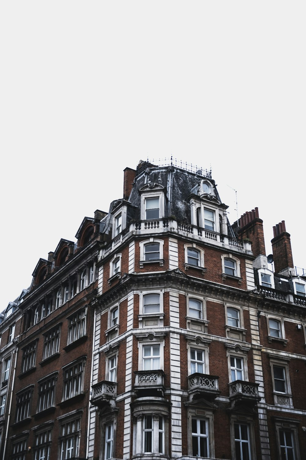 maroon and white concrete mid-rise building under white sky