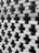 A detailed close-up view of a meticulously arranged stack of bricks, creating a pattern with gaps between them. The bricks are aligned in a staggered manner, forming a visually intriguing architectural structure.