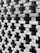 A detailed close-up view of a meticulously arranged stack of bricks, creating a pattern with gaps between them. The bricks are aligned in a staggered manner, forming a visually intriguing architectural structure.