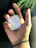 Close-up of a hand holding a neon blue silicone AirPods case with a smooth matte finish.