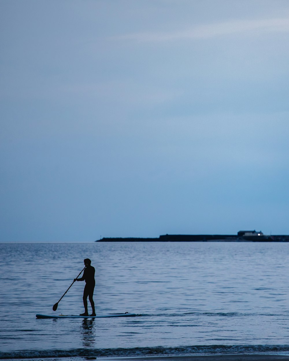 silhouette photography unknown person paddle boarding outdoors