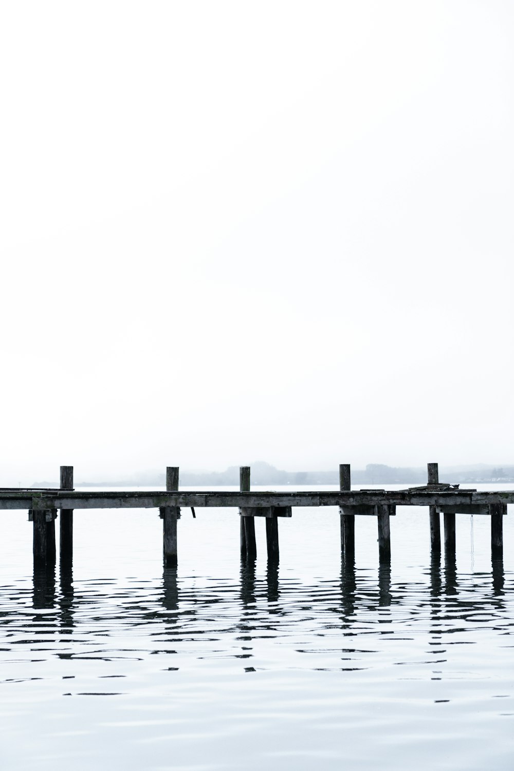 a long wooden dock sitting in the middle of a body of water