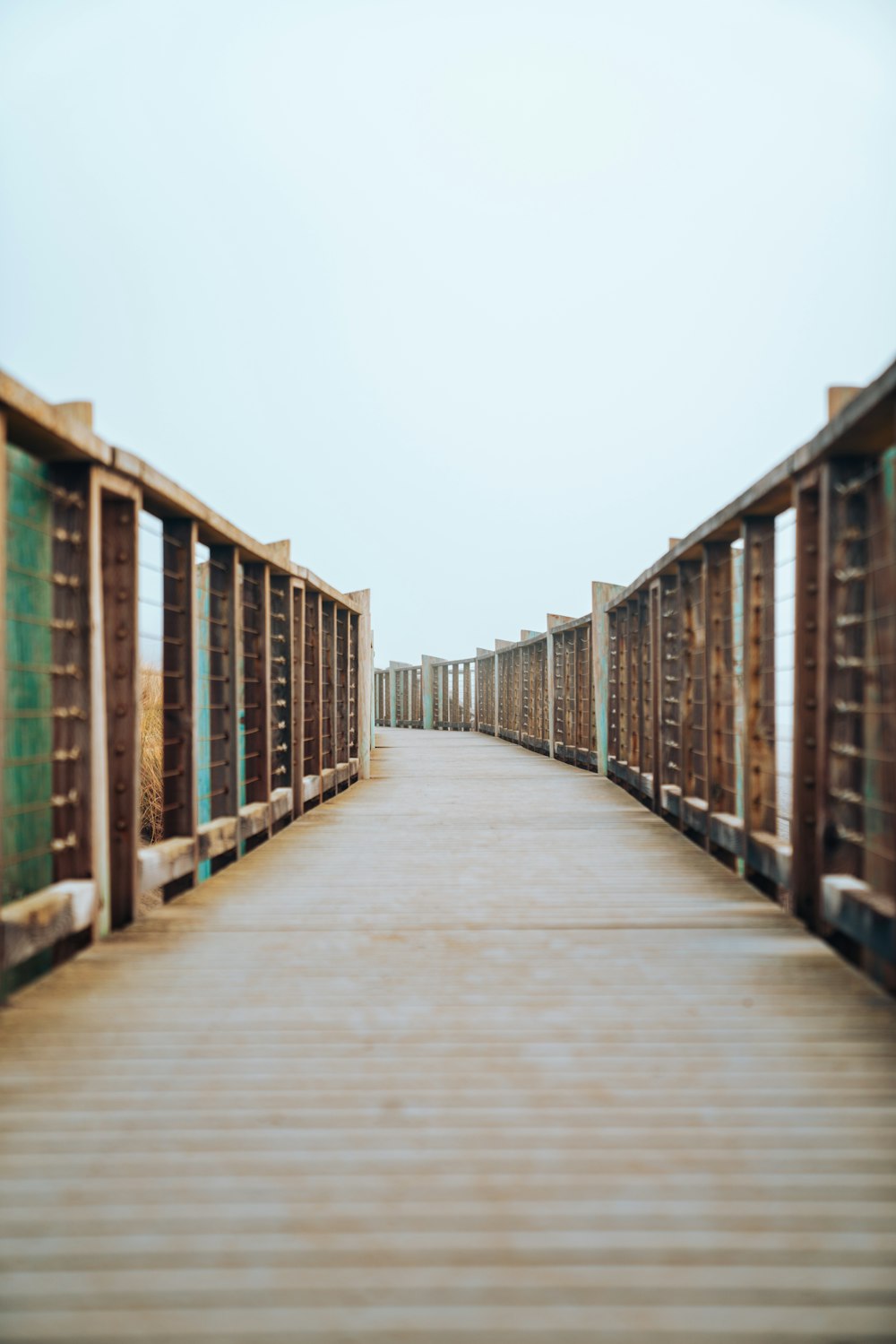 wooden pathway with railing during day