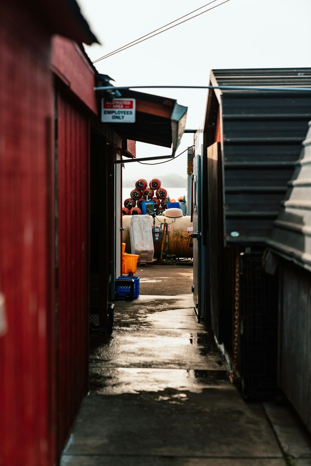 a narrow alley way with a red building in the background