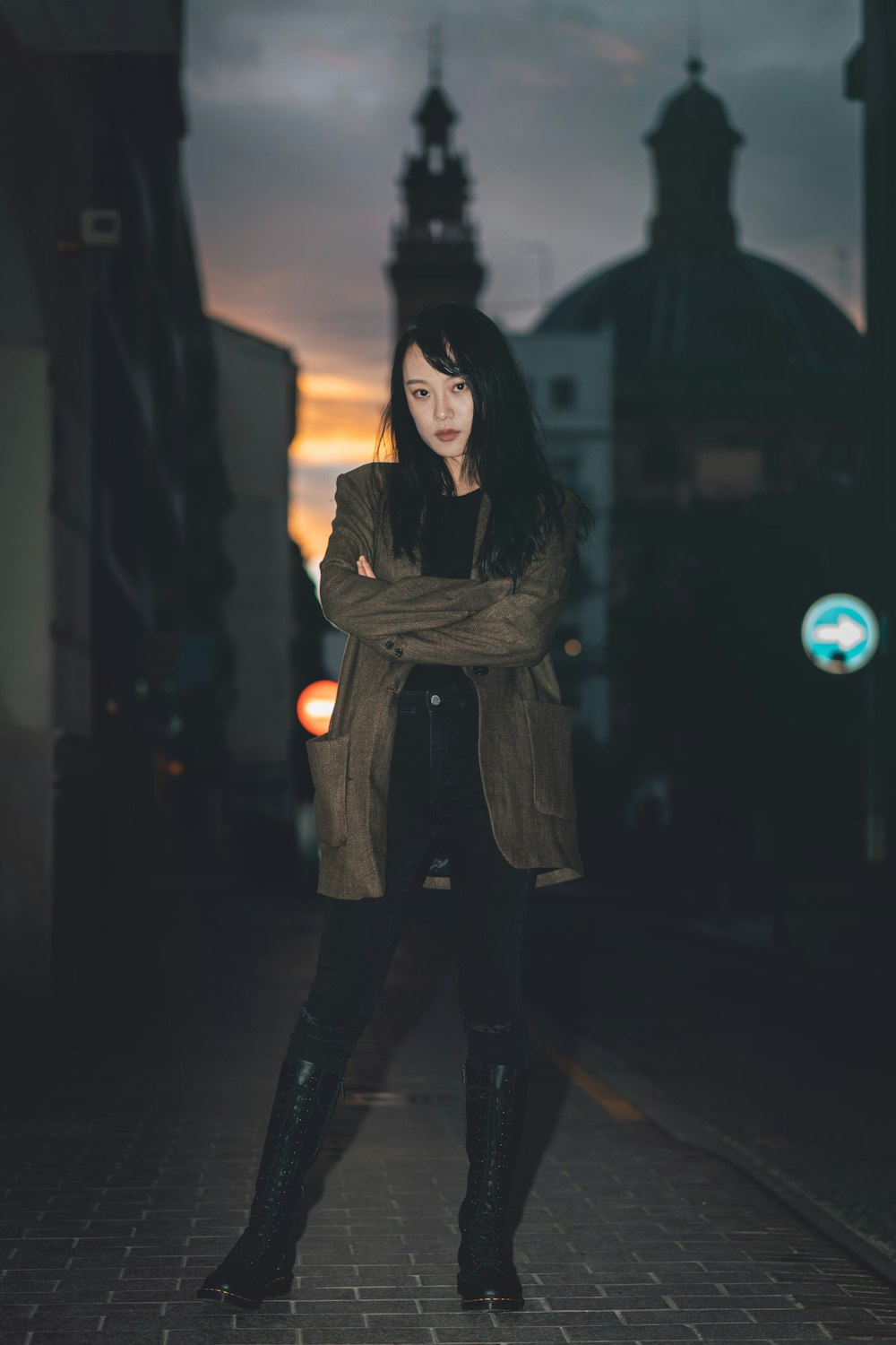 woman in brown jacket and black pants standing outdoors