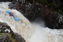 person kayaking on river