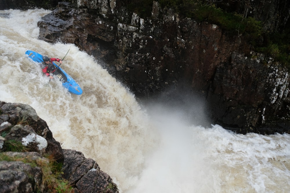 person kayaking on river