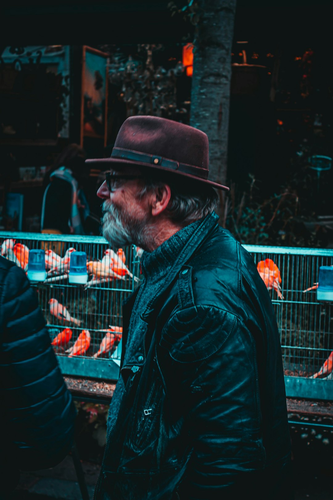 shallow focus photo of man in black leather jacket wearing brown fedora hat