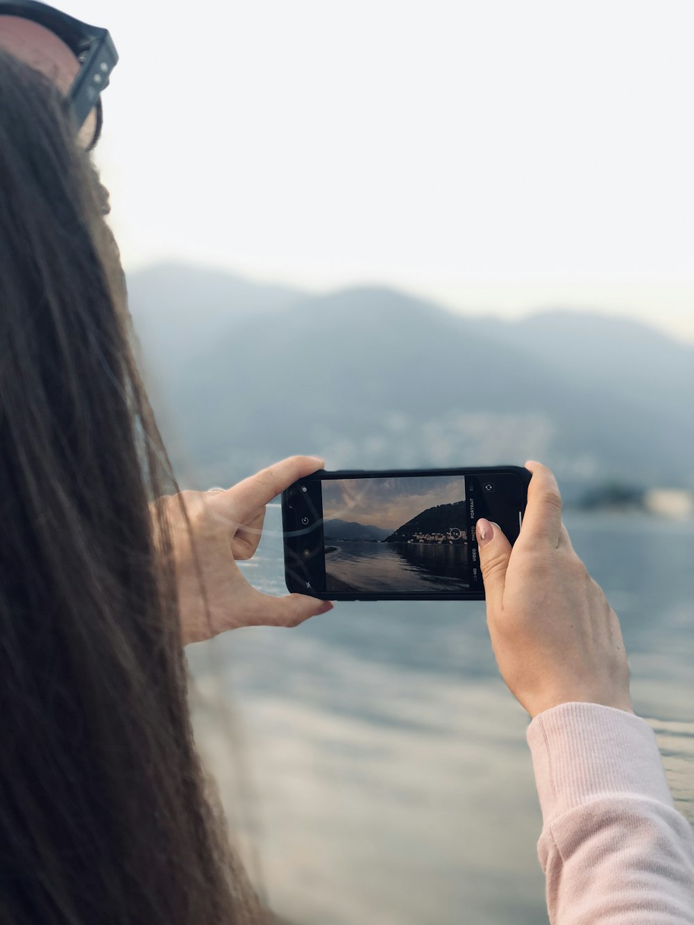 woman taking picture of the beach