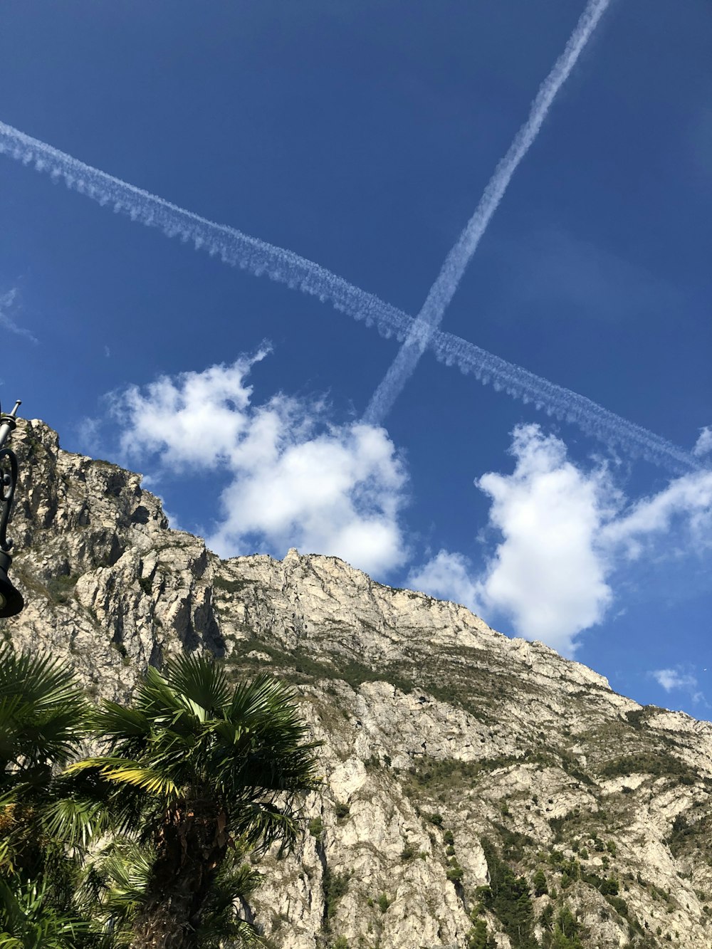 Fotografía de ángulo bajo del acantilado de la montaña bajo el cielo azul y blanco