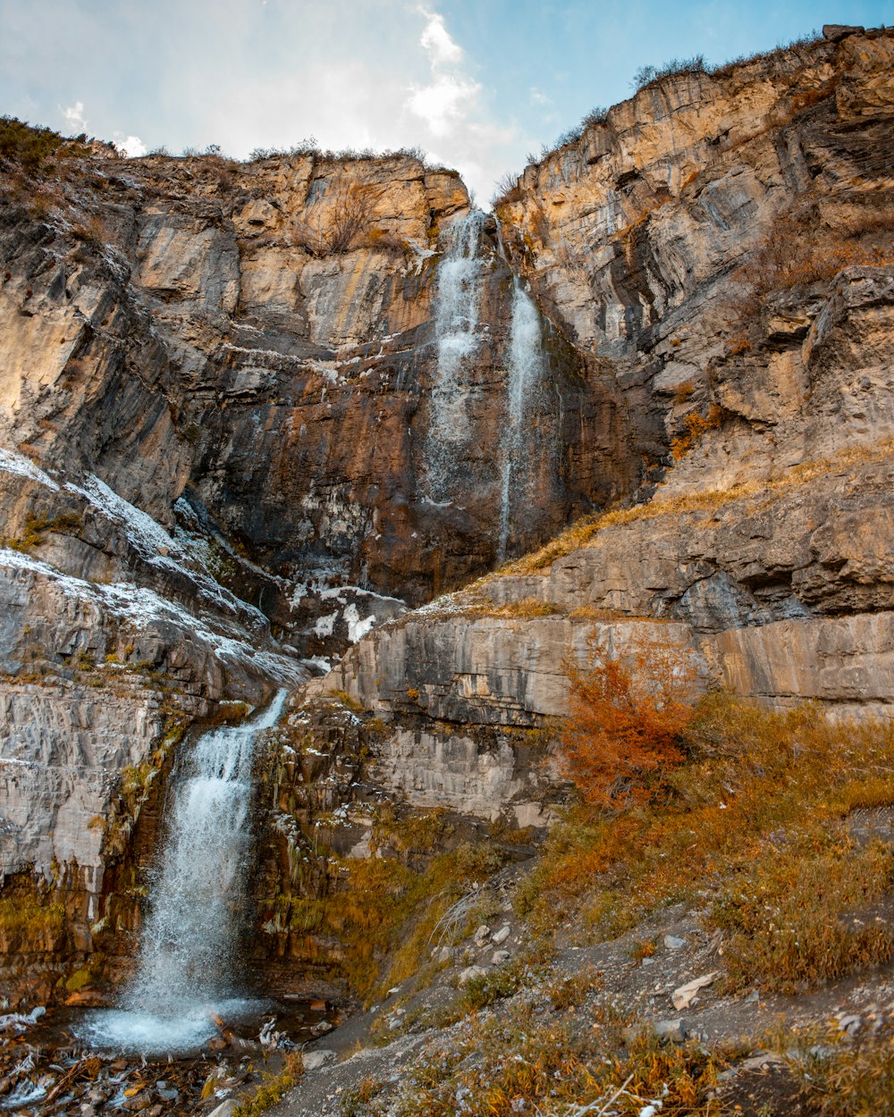 waterfalls under white and blue sky