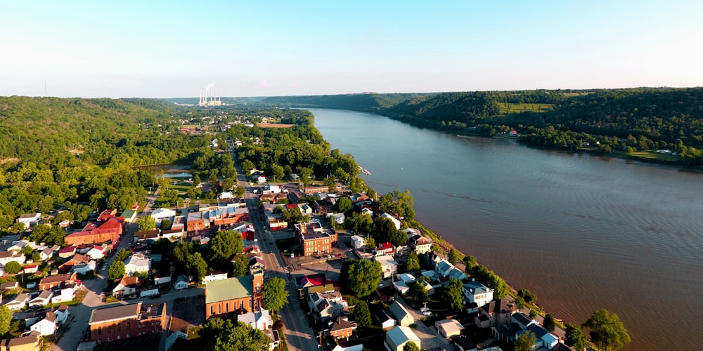 aerial photography of houses near body of water viewing mountain under white and blue sky