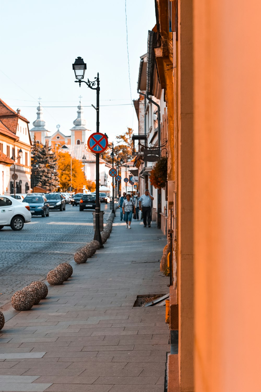 people walking at the sidewalk beside buildings and cars on road