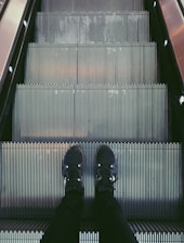 person standing on escalator
