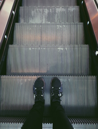 person standing on escalator