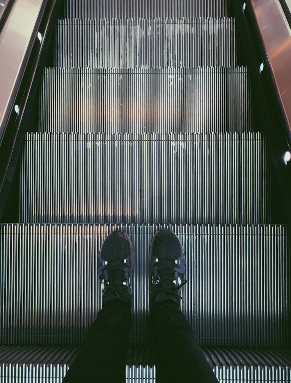 person standing on escalator