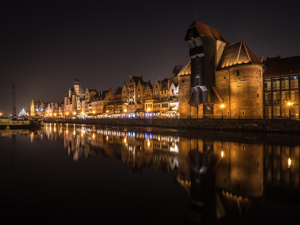 castle with lights near body of water