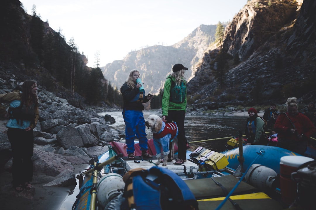 two women on boat on river surrounded by mountains