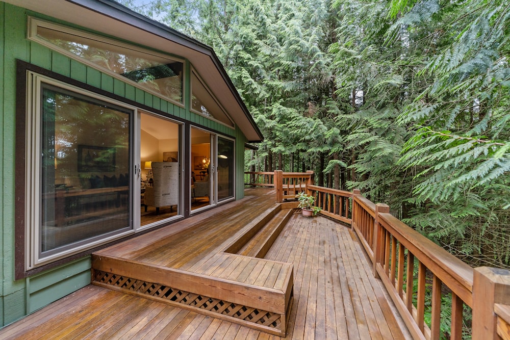 Terrasse en bois marron à l’extérieur de la porte en verre transparent