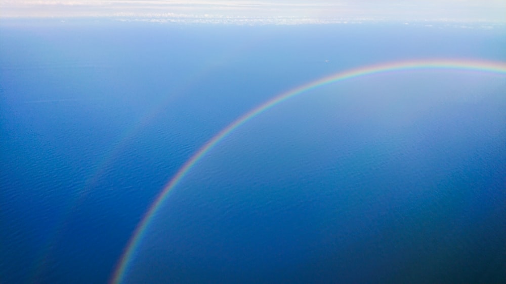 a rainbow appears over a body of water