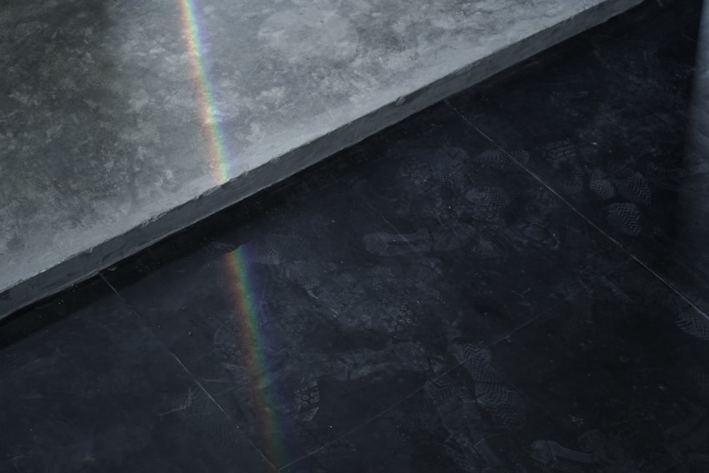 a rainbow shines in the sky over a black floor