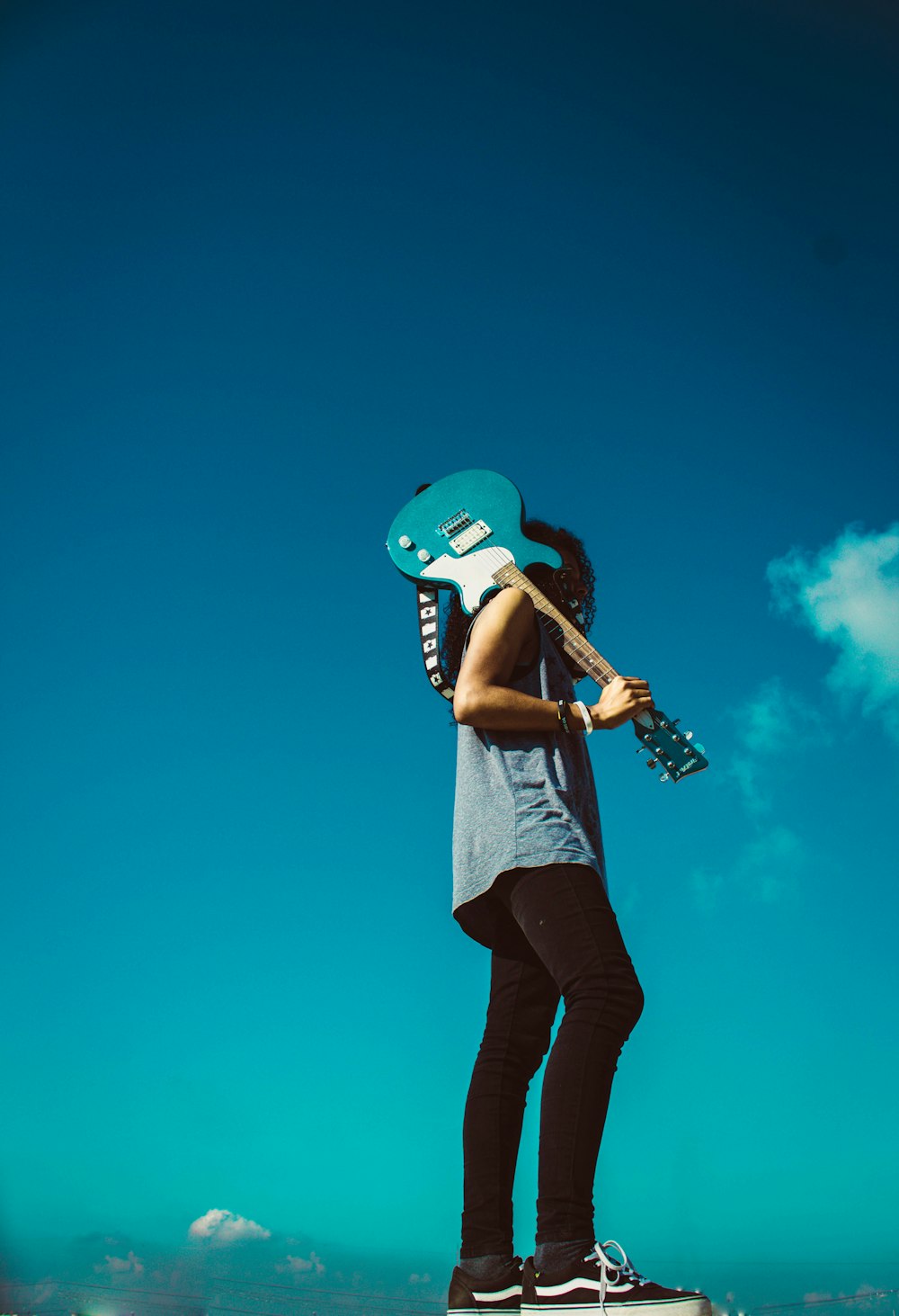 man holding blue guitar