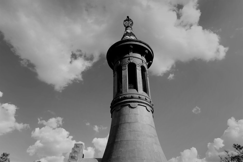 grayscale photography of tower under clouds