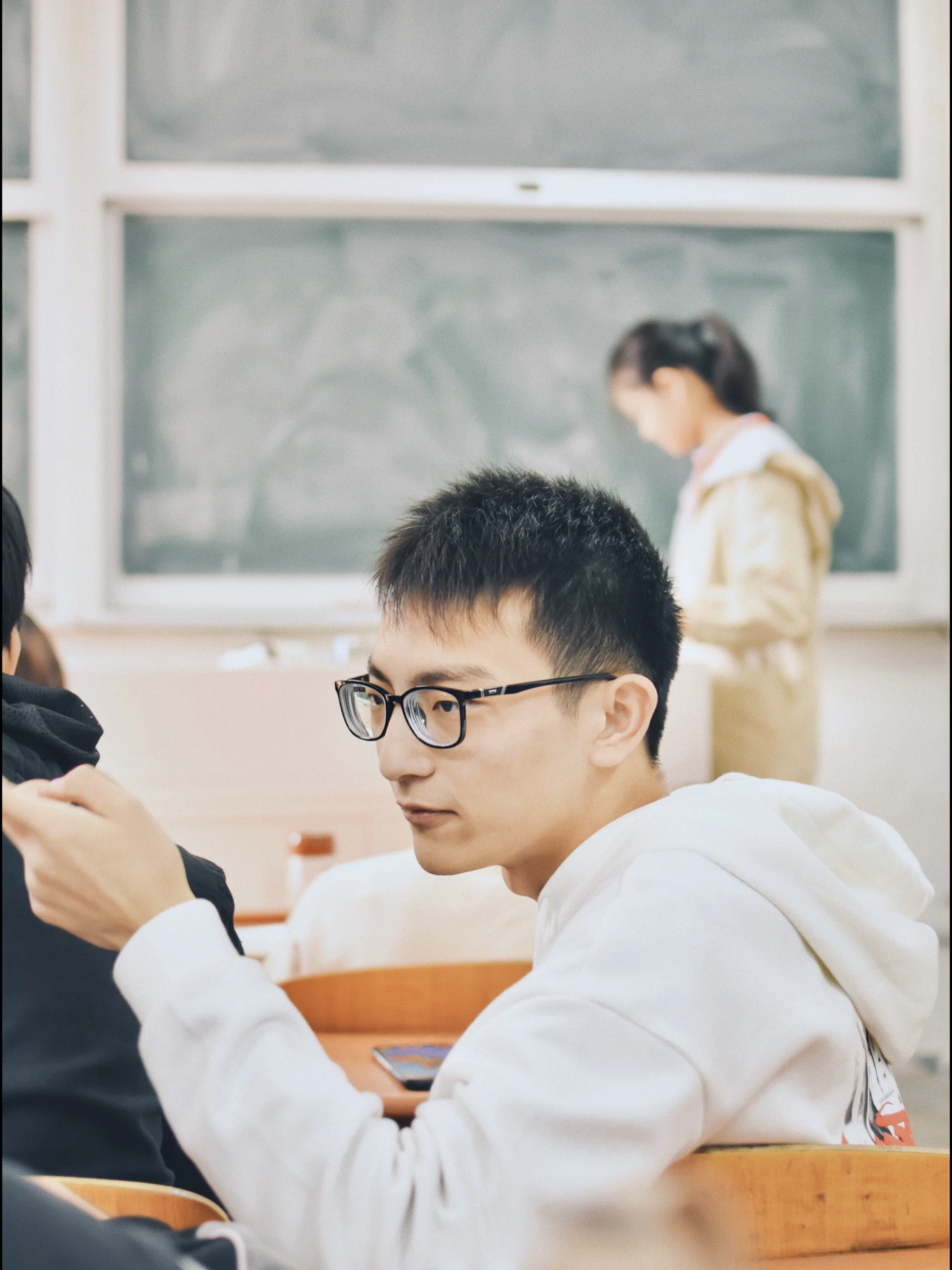 Students standing and sitting together inside a college classroom