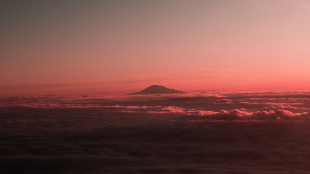 mountain surrounded with clouds during sunset