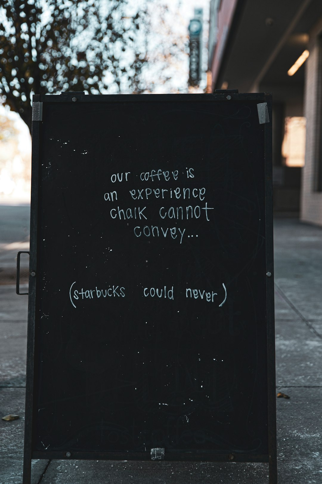 our coffee is an experience chalk cannot convey sign on chalkboard easel near building during day