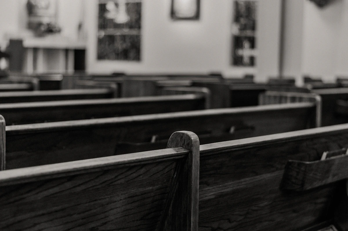 Empty wooden church pews in black and white